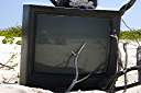 Television, Anegada style.
Nancy found this television on the beach on Anegada's north shore.  We dressed it up a bit, making the "rabbit ear" antenna from an oil bottle, some sand and sticks.  A nice little coral nick-nack on top, and we are ready to watch television.  It turns out that our reflection is the only thing that we can receive on it.