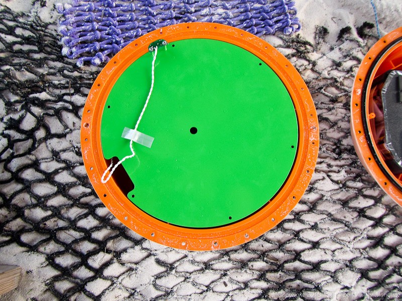 The inside of the new treasure. The top half contains the electronics bay. The black object on the edge of the green disk is an ocean temperature sensor.