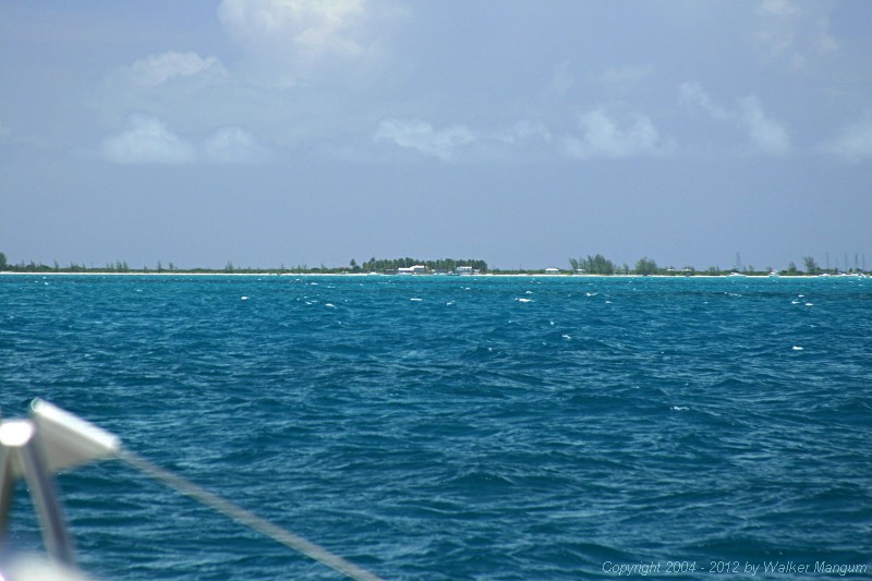 Anegada from one and a half miles out through a telephoto lens. It is what you would see with a good pair of binoculars. The white roof in the center is Neptune's Treasure, which is the most important visual landmark for approaching the Anegada entrance channel.